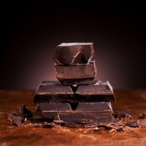 Pieces dark chocolate on a marble brown background